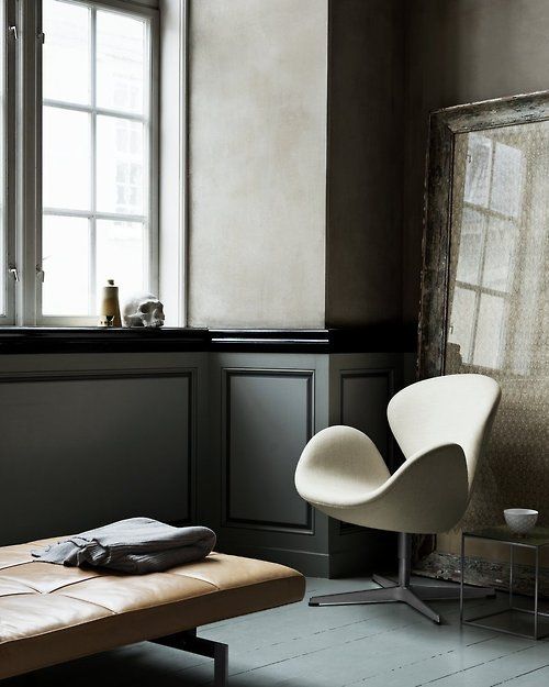 a neutral vintage nook with an oversized artwork in a heavy frame, a white Swan chair and a leather upholstered bench