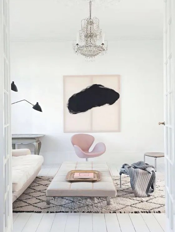 a pastel living room with a creamy sofa and ottoman, a pink Swan chair, a crystal chandelier and some stools