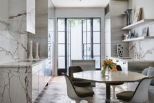 a refined eat-in kitchen with marble cabinets and a hood, open shelves, a geometric table and Tulip chairs
