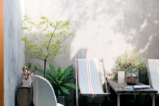 an outdoor space with hammock chairs and a Panton one, a stained table and some potted plants is cool