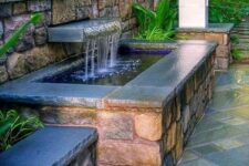02 a beautiful waterfall with a large water feature in stone and brick and surrounded with greenery and bold blooms is a cool idea