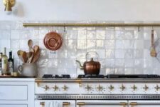 03 a beautiful vintage white kitchen with gold fixtures and a gorgeous white zellige tile backsplash that adds shine, interest and texture
