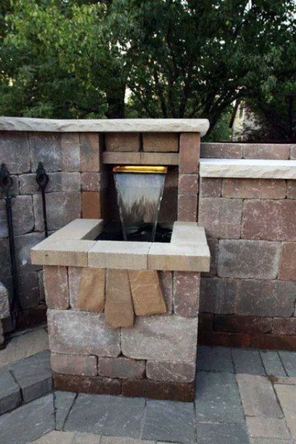 a cool backyard waterfall built into a rock wall is a lovely idea if you want a waterfall but with a modern feel