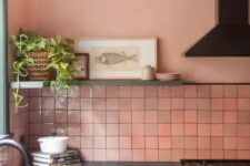 07 a gorgeous kitchen with pink zellige tiles, green cabinetry, black appliances and fixtures, a shelf with some art and a potted plant
