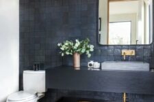 09 a modern bathroom with grey and black zellige tiles, a black floating vanity and a shelf, a mirror, a catchy pendant lamp and some decor