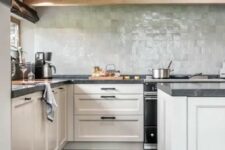 12 a modern farmhouse kitchen with neutral shaker cabinets, black stone countertops, a pale green zellige tile backsplash