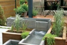 12 a modern outdoor space clad with a wooden deck, with a modern waterfall of concrete boxes and greenery is a cool and edgy nook