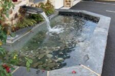 13 a modern pond with pebbles inside and stone borders plus a waterfall is a cool feature for an elegant garden
