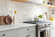 14 a modern grey kitchen with a zellige tile backsplash, open shelves, a hood and black knobs for a catchy detail