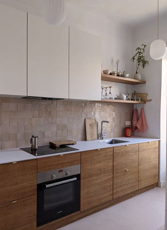 a two-tone kitchen with neutral and stained cabinets, a white countertop and a beige Zellige tile backsplash