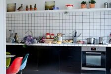 23 a bold kitchen with black cabinets and a white square tile backsplash, a bold rug and colorful chairs at the table