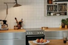 25 a catchy Nordic kitchen with sleek grey cabinets, butcherblock countertops, a white square tile backsplash and a shelf