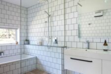 27 a catchy modern bathroom clad with white square tiles, with a large shower and tub space, a wooden floor there and a floating vanity