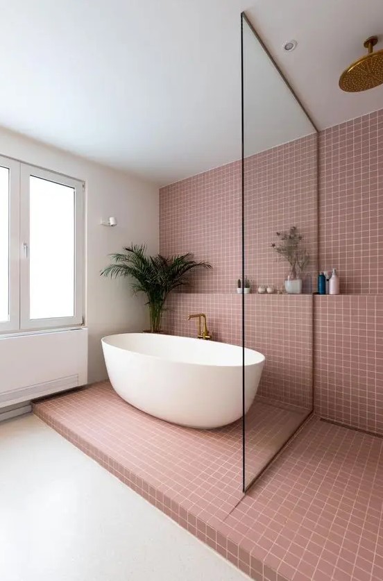 a contemporary bathroom with mauve square tiles, a shower space and an oval tub, a shelf and some decor and greenery