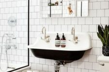31 a contrasting modern bathroom with white square tiles and hex tiles on the floor, a black wall-mounted sink, a mirror and some potted plants