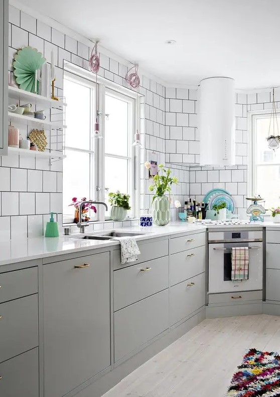 a Nordic kitchen with grey lower cabinets, white square tiles on the walls, a round hood and open shelves is lovely