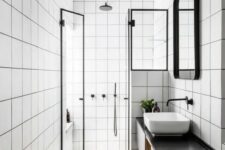 42 a modern bathroom with white square tiles, a floating black vanity, a shower space, a sink, a mirror in a frame and some lights