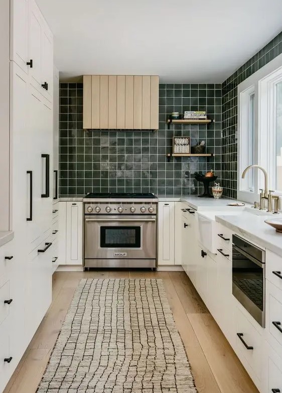 a Scandinavian kitchen with shaker cabinets, a dark green square tile backsplash, white stone countertops and a shiplap hood