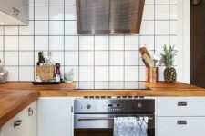 45 a Scandinavian kitchen with white cabinets, white square tiles on the walls, butcherblock countertops and stainless steel appliances