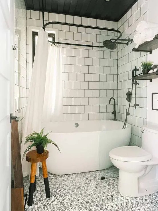 a neutral bathroom with white square tiles and a printed tile floor, white appliances, a wooden stool and black fixtures
