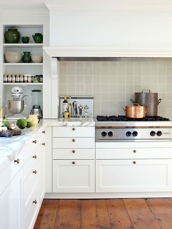 a white farmhouse kitchen with white stone countertops and a grey square tile backsplash and open shelves