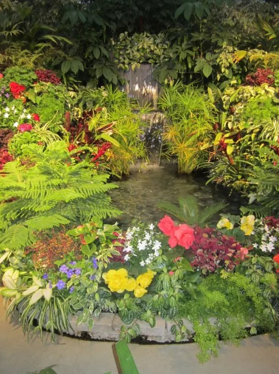 Surround your garden waterfall with flowers and it'd look like it was there before your house.