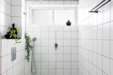 57 a small neutral bathroom with white square tiles, a green and white tile floor, a window, neutral appliances and black touches