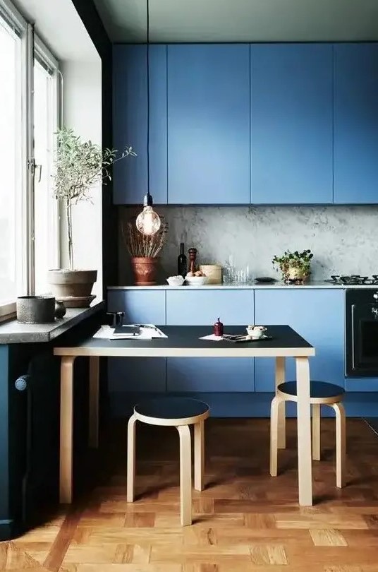 a blue minimalist kitchen with a grey marble backsplash and a black dining set for a gorgeous look