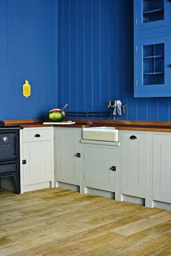 a bold kitchen with electric blue shiplap walls and upper cabinets, grey lower ones and butcherblock countertops is amazing