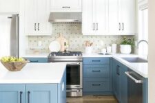 a breezy kitchen with pastel blue and white cabinets, a printed tile backsplash, white countertops, black handles
