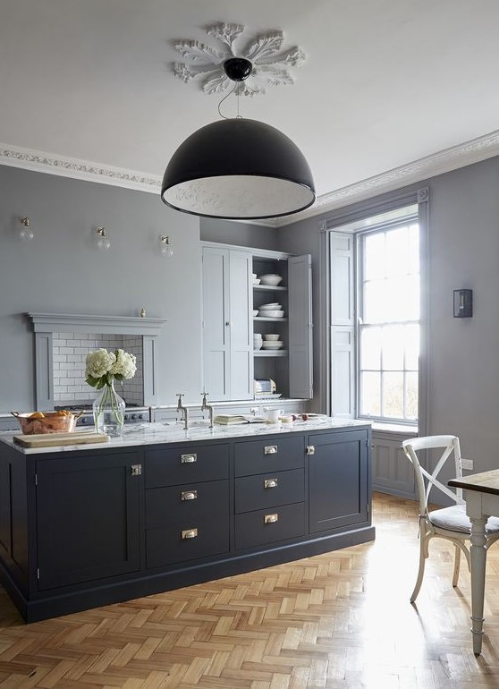 a chic dove grey kitchen with a midnight blue kitchen island and touches of brass that make it more refined and gorgeous