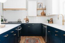 a contrasting kitchen with lower navy cabinets and white upper ones, a white tile backsplash and white countertops, a lamp on chain