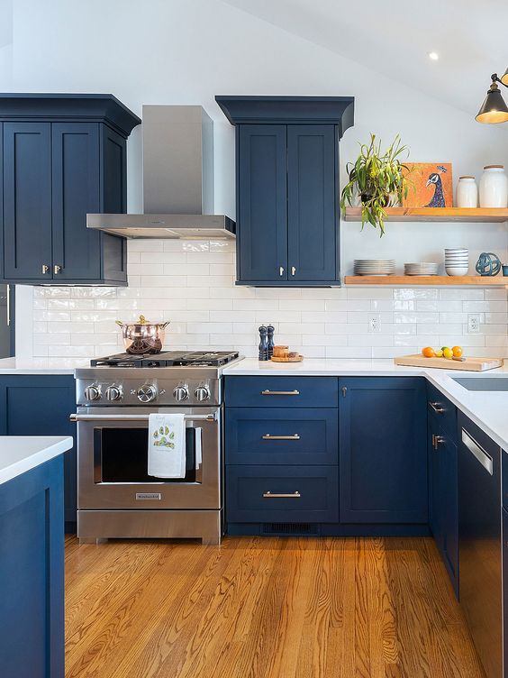 a contrasting kitchen with navy shaker cabinets, a white tile backsplash and countertops, open shelves and black sconces