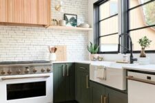 a cool kitchen with green cabinets, built-in appliances, a white brick backsplash and a stained wood hood