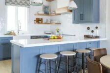 a fab coastal kitchen with blue cabinets, white stone countertops and glossy tiles, light-stained shelves and wooden beams