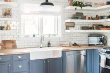 a lovely farmhouse kitchen with coean blue lower cabinets, open shelves, white subway tiles, butcherblock countertops