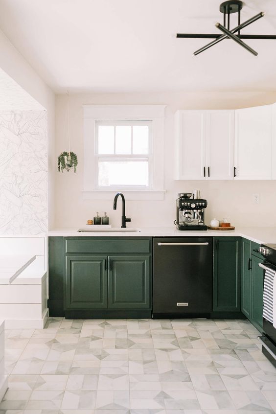 a lovely two-tone kitchen with dark green and white cabinets, white countertops and a backsplash, black fixtures