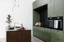 a minimalist olive green kitchen with sleek cabinets, a black backsplash and countertops, a stained kitchen island, gold touches