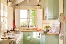 a mint farmhouse kitchen with beadboard cabinets, butcherblock countertops and lots of natural light