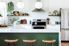 a modern farmhouse kitchen with white cabinets, a penny tile backsplash, a green kitchen island, wooden stools and potted greenery