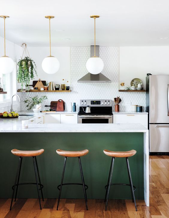a modern farmhouse kitchen with white cabinets, a penny tile backsplash, a green kitchen island, wooden stools and potted greenery