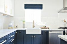 a modern farmhouse kitchen with white upper and navy lower cabinets, white tiles, a boho rug and white stone countertops