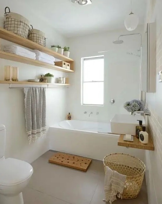 a small and serene bathroom with a tub, open shelves, a sink, wicker and wooden touches here and there
