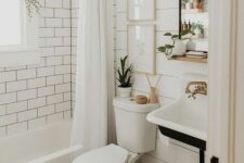 a small farmhouse bathroom with shiplap and white subway tiles, a tub, a wall-mounted sink, some decor and potted greenery