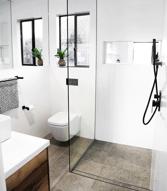 a small modern bathroom with a shower, a vanity with a sink and black touches for an edgy feel in the space