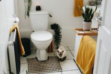 a small modern bathroom with a tub and a shelf, a wall-mounted sink, potted greenery and yellow towels is super cool