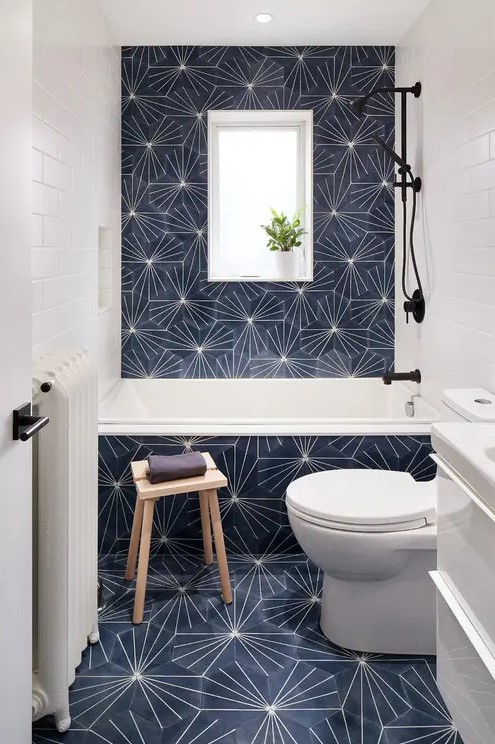 a small modern bathtoom with eye-catchy hexagon tiles, white appliances and black fixtures