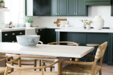 a stylish dark green kitchen with shaker cabinets, white quartz countertops and a backsplash plus pendant lamps on chain