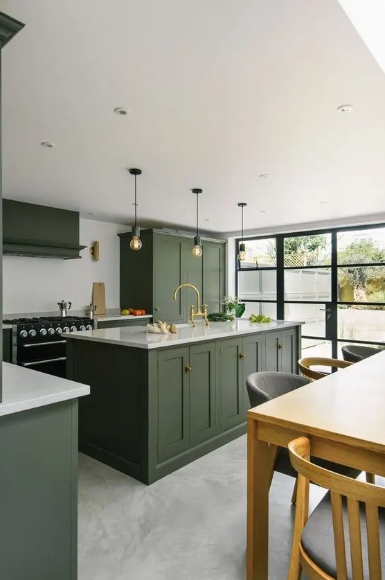 a stylish hunter green kitchen with vintage cabinetry, a white backsplash and countertops, pendant bulbs and a glazed wall