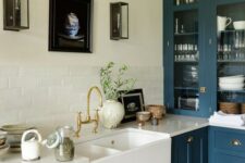 a teal kitchen refreshed with a white tile backsplash and countertop plus gold handles and fixtures